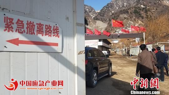 图为3月25日，秦岭金矿救援现场外围，可见安全警示标语。　王登峰 摄
